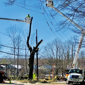 Utility crews trimming trees and restoring power lines along Bedford Road at Maple Avenue in Armonk.
