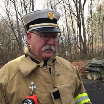 New Canaan Fire Chief Jack Hennessey at the scene of Friday's fire at 610 Cheese Spring Road.