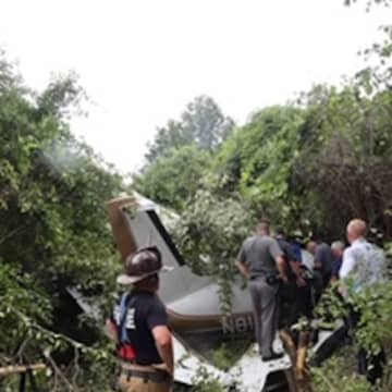 First responders work to remove a trapped passenger from a small airplane that crash.