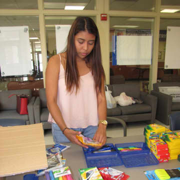 Mount St. Mary College senior Gabriela Monroy. of Mamaroneck, a human services major, helps stuff book bags with school supplies on Friday, Sept. 4.