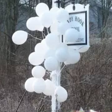 A memorial at the Sandy Hook School sign is a reminder of the shooting massacre of 26 people at the Newtown school. Lawyers for Remington Arms are trying to get a judge to dismiss a lawsuit against the gun manufacturer, the Hartford Courant reported.