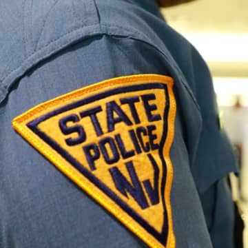 A New Jersey State Trooper was hospitalized with minor injuries after his parked car was slammed by an Audi on the Garden State Parkway, authorities said.