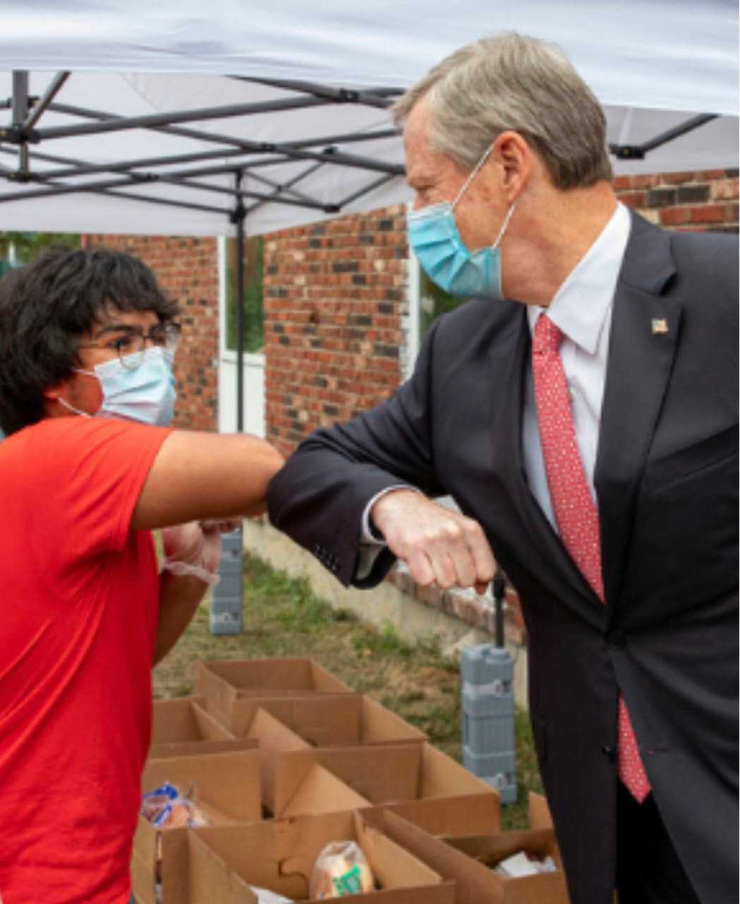 Gov. Charlie Baker exchanges a COVID-19-friendly elbow bump with a farmer's market vendor.