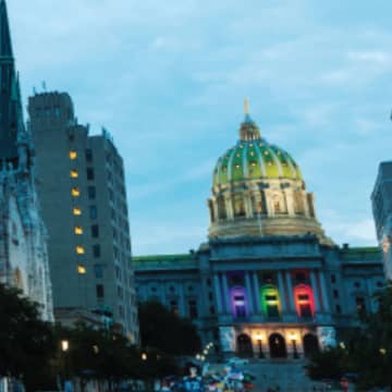 LGBTQ+ rights event at the Pennsylvania state capital; the capital is show with rainbow lighting in support of the LGTBQ+ movement