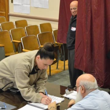 A voter signs in at Bergenfield Borough Hall with Joseph Gorgone, poll worker. By 4:30 p.m.,  48.8 percent of the voters in his district had cast ballots. "That's the highest in 15 years," he said.