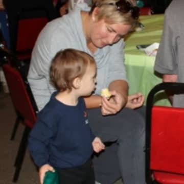 Elizabeth Pimdulik feeds her one-year-old son, Logan at a table with her father-in-law, Fillip Pimdulik at the Dumont Elks Lodge during Family Fun Day. 