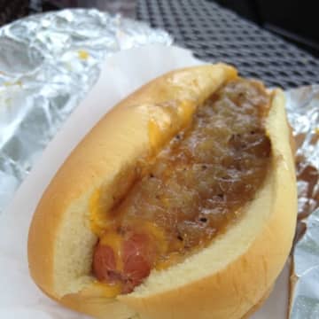 A "link" at Lubins-N-Links in Tarrytown is covered with homemade Jubee onions and "cheez," a blend of four different cheeses.