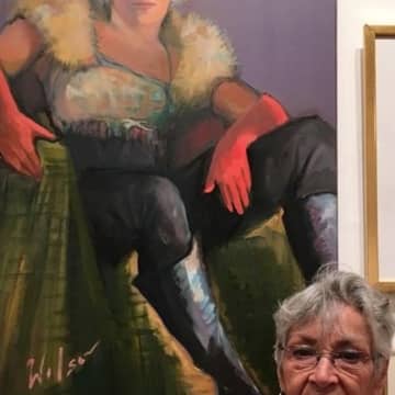 Pat Wilson, of Teaneck, stands with her oil portrait, "Bobbie in Red Gloves."