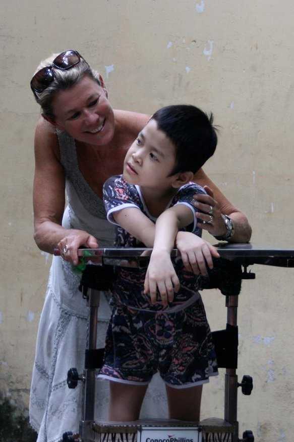 Darien's Lynn Gagliardi assists a child during her recent trip to an orphange in Vietnam.
