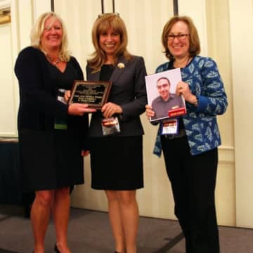Dawn LaValle, director of library development at the Connecticut State Library, presents the Connecticut Library Associations 2015 Excellence in Public Library Service award to Wilton Librarys Mary Anne Mendola Franco and Susan Lauricella.