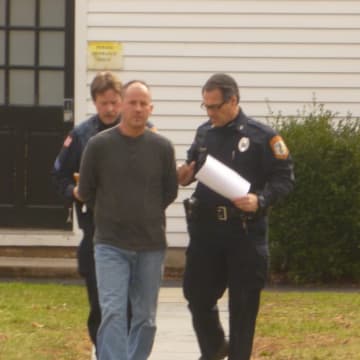Pound Ridge police officers escort David Pinchbeck to his arraignment where he was charged with fourth-degree stalking.