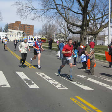 A crowd of runners approaches the finish line in the Danbury Half Marathon.