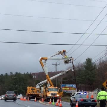 Utility crews repair a pole after a crash Wednesday morning on South Main Street in Newtown.