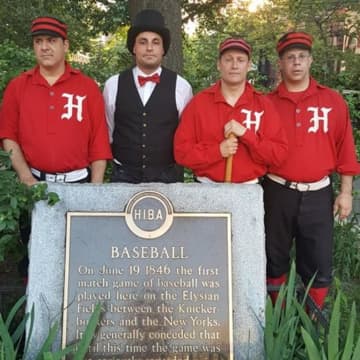 Members of the Hoboken Nine Vintage Base Ball Club stand with a historic marker.