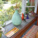 The windowsill features unqiue vases.