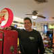 Sycamore owner Patrick Austin poses next to a gas pump.