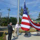 Bottle King owner Kenneth Friedman and members of the American Legion and VFW raising the flag