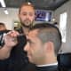 The Shave Bar & Barbershop owner Evan Vidal cuts Ali Poury's hair in the Broadway shop.