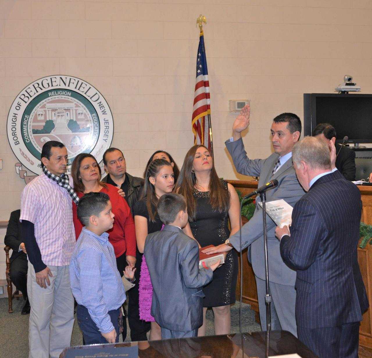 Councilman Hernando Rivera takes the oath of office for his second term as Bergenfield councilman with family looking on. His oath was given by 38th District Assemblyman Robert Gordon.