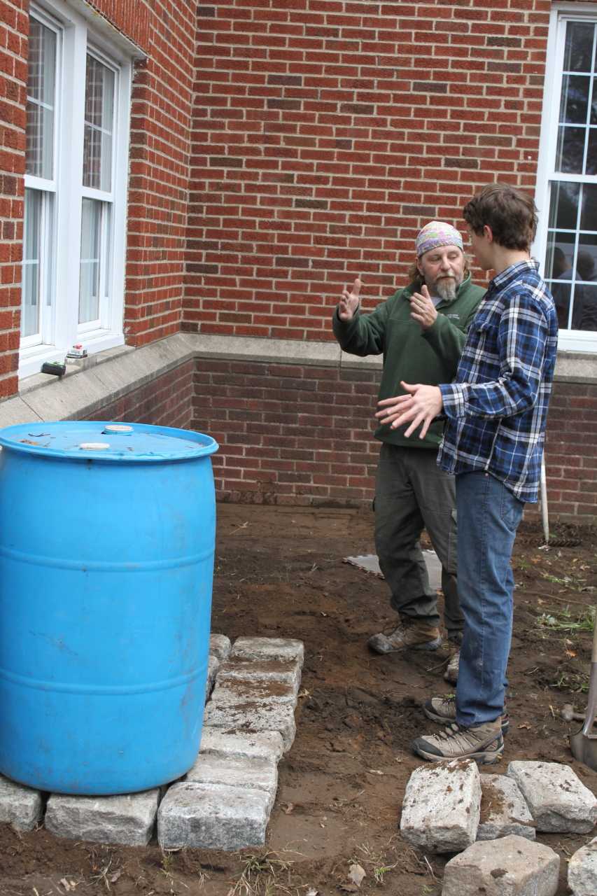 Derek Ravensbergen and Scoutmaster Sal Maurice discuss the water collection system.