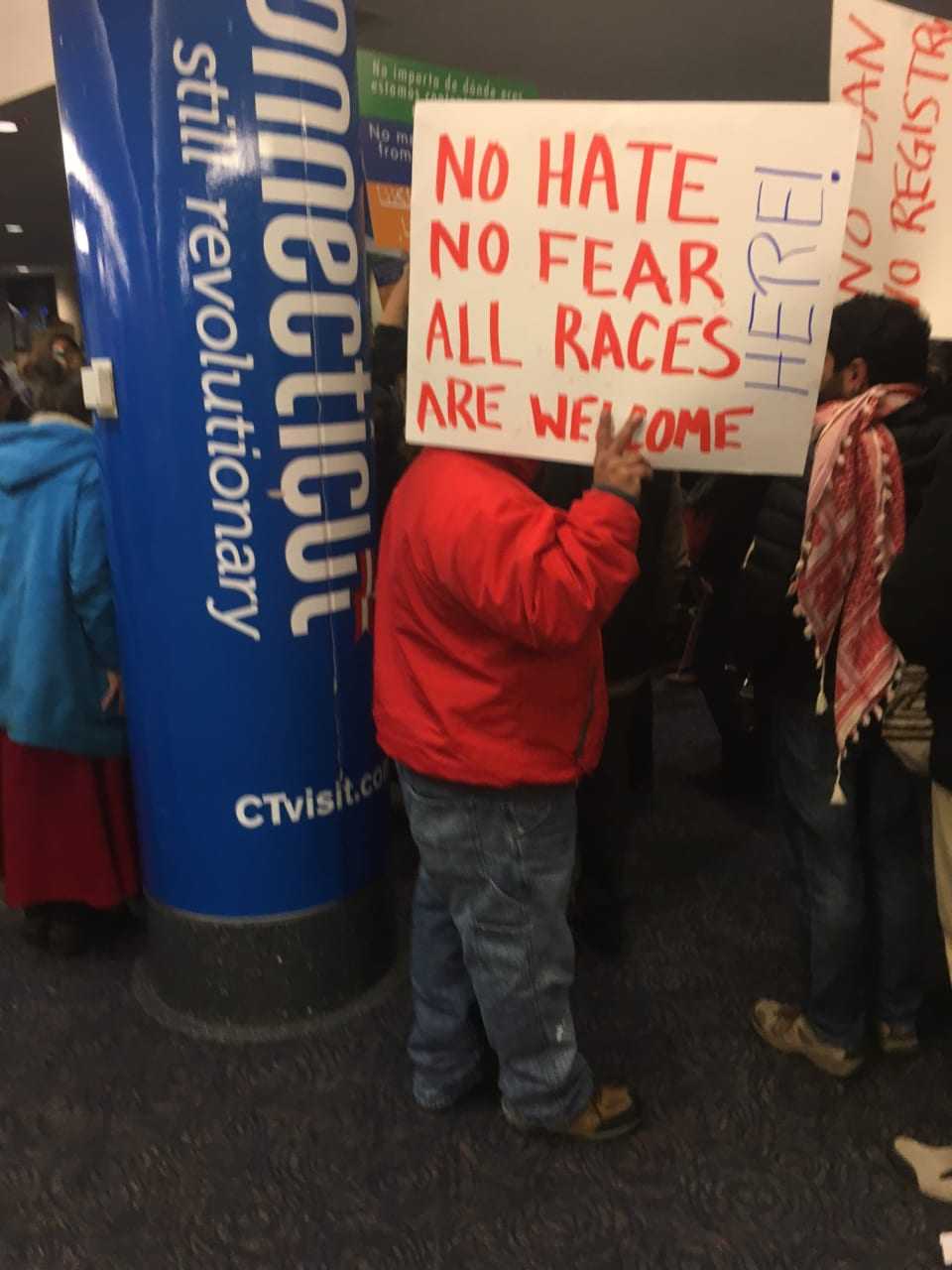 The protest at Bradley International Airport greets arriving passengers — along with a pole emblazoned with the state's tourism motto: Connecticut Still Revolutionary.