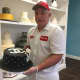David Miller of Millers Bakery holds a Chanel cake decorated by his wife.