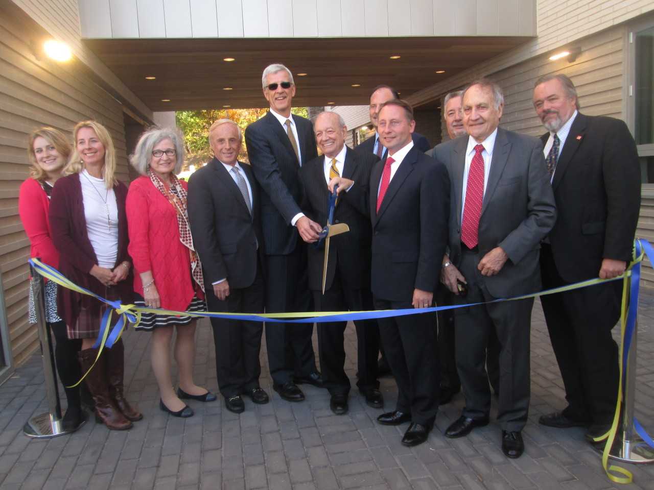 Officials gather for a ribbon cutting at alumni hall at Pace University. 