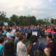 Participants form a circle around the speakers at the rally in Mill River Park in Stamford.
