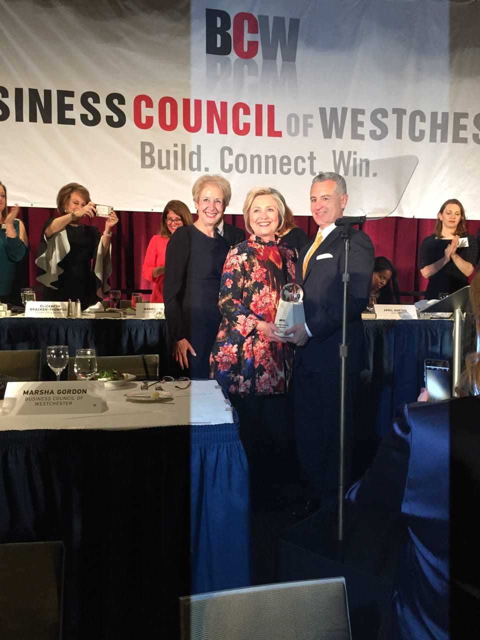 Hillary Clinton, center, with Anthony Justic, BCW Board Chairman, right, and BCW President and CEO Marsha Gordon, left.