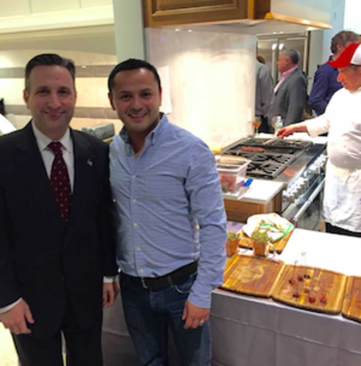 State Sen. Bob Duff, left, with Marco Siguenza, owner of Washington Prime restaurant at the Galaxy of Gourmets for STAR event Thursday in Norwalk. Washington Prime employee Eleazar Moran, in back, is busy cooking the steak being served.