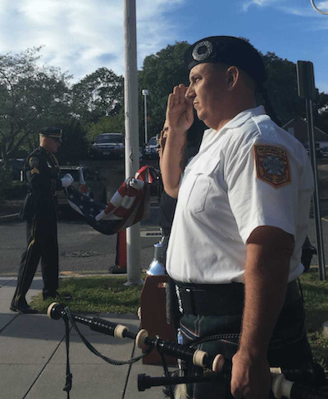 A bagpiper salutes as the American flag is lowered during the 9/11 event in front of Norwalk City Hall Friday morning.