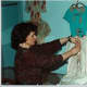 New Canaan Historical Society Executive Director Janet Lindstrom puts finishing touches on a costume exhibit.
