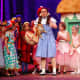 Dorothy (Kate Murphy) and munchkins in cast of "The Wizard of Oz" at New Canaan High School.