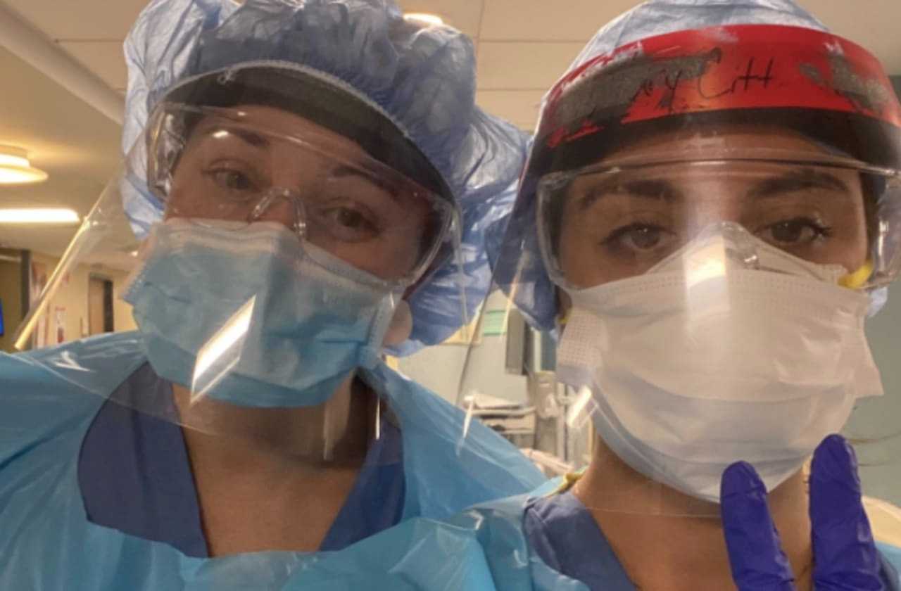 Hospital workers display face shields donated by Hatteras Printing of Tinton Falls.