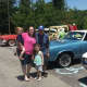 An Atria resident and his family standing with the classic cars on display at the show.