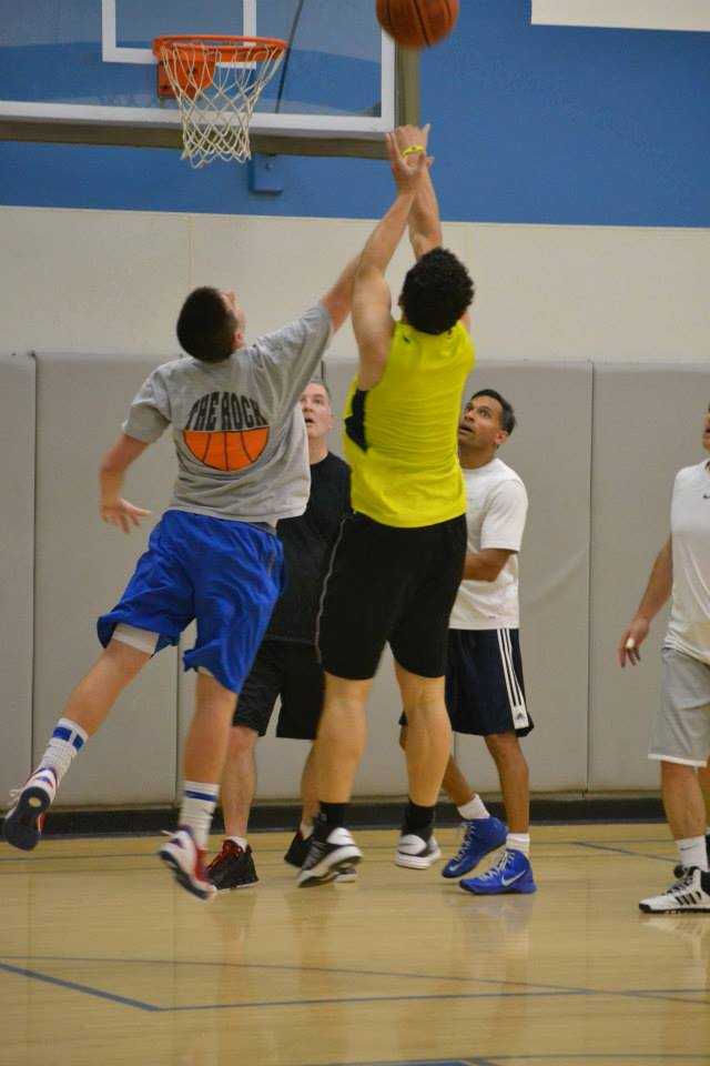 Men participate in basketball games on the Club Fit court. 
