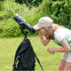 A camp participant looks into a telescope to view the surrounding area. 