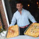 Frank Polozani holding samples of food during Thursday's Taste of the Town Stroll in New Canaan.