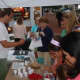 MacKenzie Judson of Mike's Organic Delivery hands out a sample during Thursday's Taste of the Town Stroll in New Canaan.