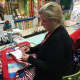 A volunteer sews the finishing touches on a quilt.