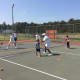 Marvin Tyler works with a young tennis player on his form.