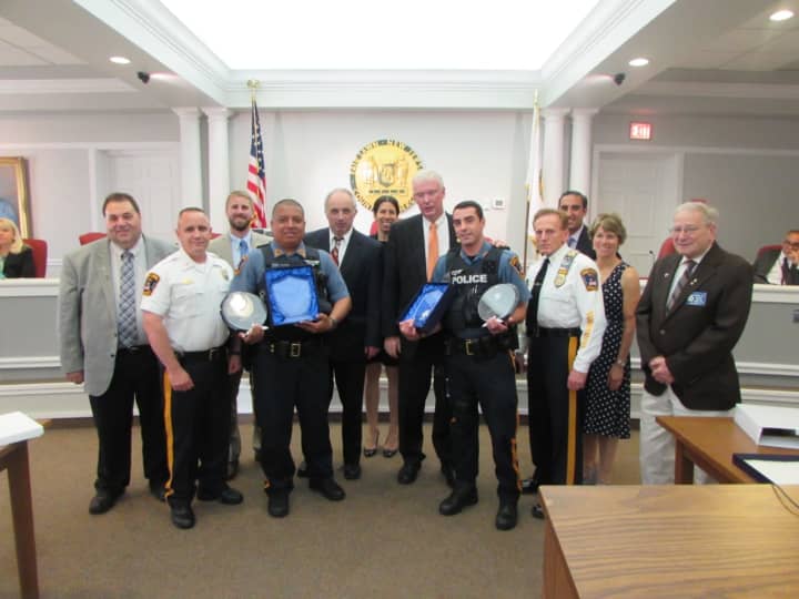 P.O. Juan Rodriguez (holding awards, left) and P.O. John Rovetto are joined by the Fair Lawn Police administration, the mayor and council of Fair Lawn &amp; members of the Knights of Columbus St. Ann’s Council #2853.