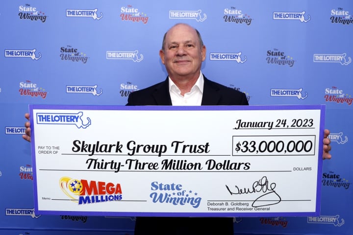 Skylark Group Trust trustee David M. Lipshutz poses with the group&#x27;s winning Mega Millions prize from the Massachusetts Lottery