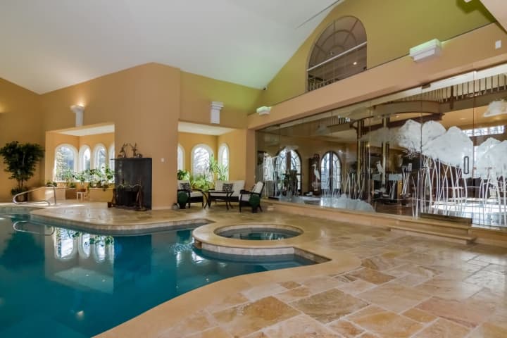 The indoor pool in this Franklin Lakes mansion can open up to the backyard.