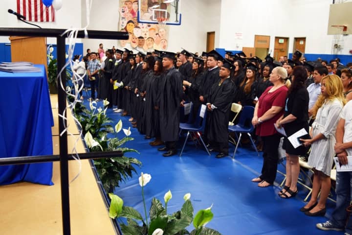 Adult Education graduates stand for the National Anthem at the Adult Education Graduation Ceremony on June 16 at Putnam/Northern Westchester BOCES.