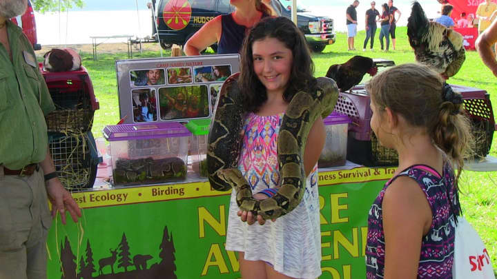 A girl poses with a 10 foot snake at the Hudson Valley Expo
