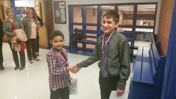 Jonell Rios Losado, left, shakes hands with Dean Fejes after the two were honored at the Putnam Valley Board of Education&#x27;s November meeting.