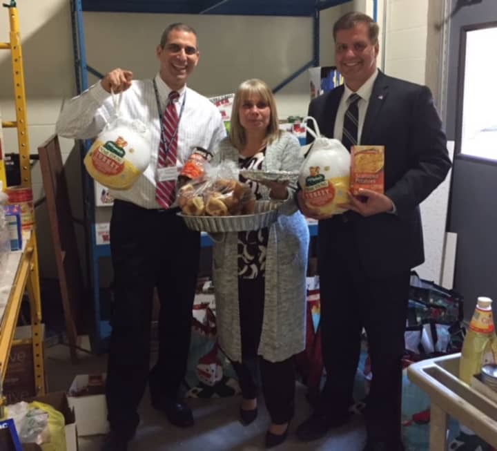 Mahopac Middle School principal Vincent DiGrandi, assistant principal Anna O&#x27;Connor and Carmel Town Councilman Frank Lombardi show off some of the food items that were gathered for those in need this Thanksgiving.