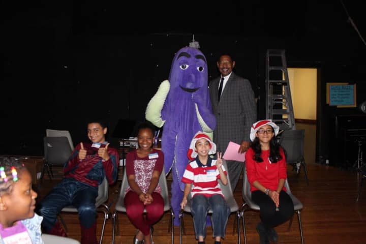 Mount Vernon Superintendent Kenneth Hamilton and OLI the Octopus with elementary students announcing this year&#x27;s Reading Challenge.
