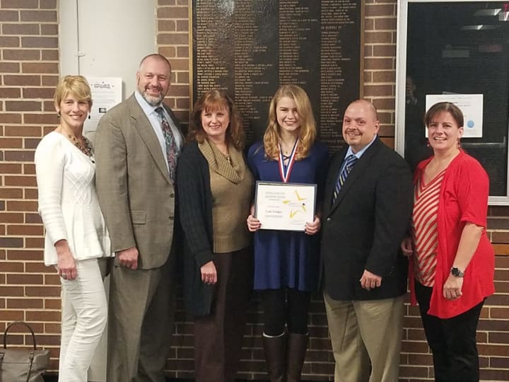 Leah Feniger with her parents and school officials after being honored as a student of distinction.